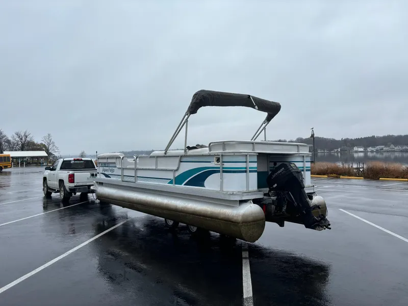 Slide: The Image of 1996 Godfrey Aqua Patio pontoon boat on trailer in rainy parking lot. - 6