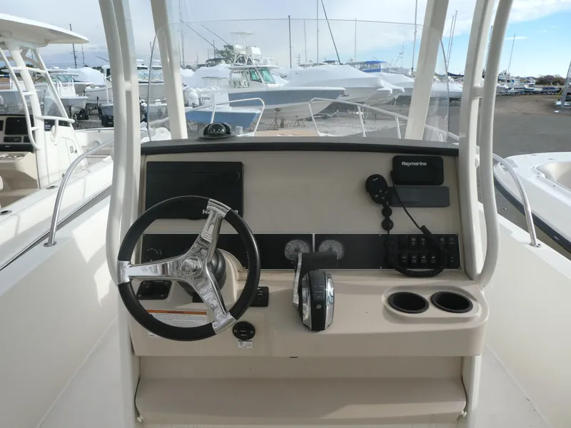 Slide: The Image of 2019 Boston Whaler 270 Dauntless boat console with steering wheel and controls. - 2