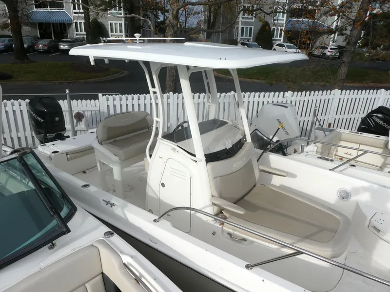 Slide: The Image of 2019 Boston Whaler 270 Dauntless boat with T-top and seating, docked near white fence. - 4