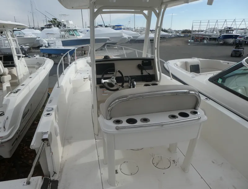 Slide: The Image of 2019 Boston Whaler 270 Dauntless boat interior, featuring helm and seating area at marina. - 6