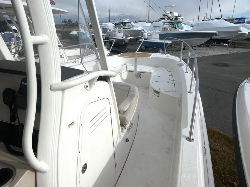 Slide: The Image of 2019 Boston Whaler 270 Dauntless boat deck, featuring seating and storage, docked in a marina. - 7