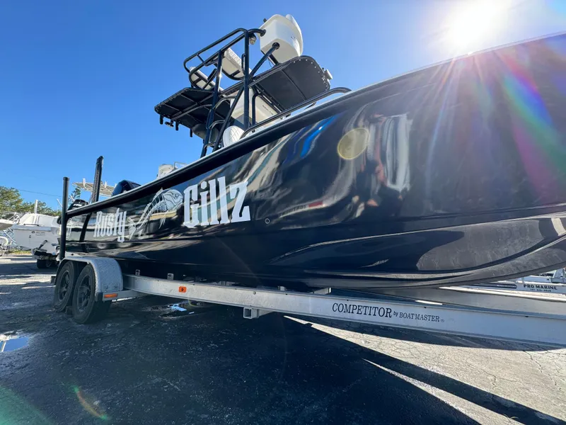 Slide: The Image of 2017 Action Craft 24 A.C.E. boat on trailer, black hull, sunny day. - 3