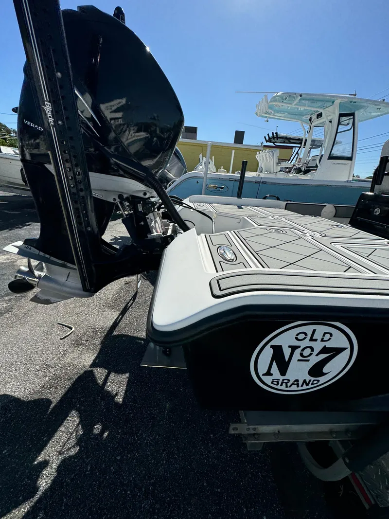 Slide: The Image of 2017 Action Craft 24 A.C.E. boat with "Old No. 7 Brand" sticker, docked under clear sky. - 38