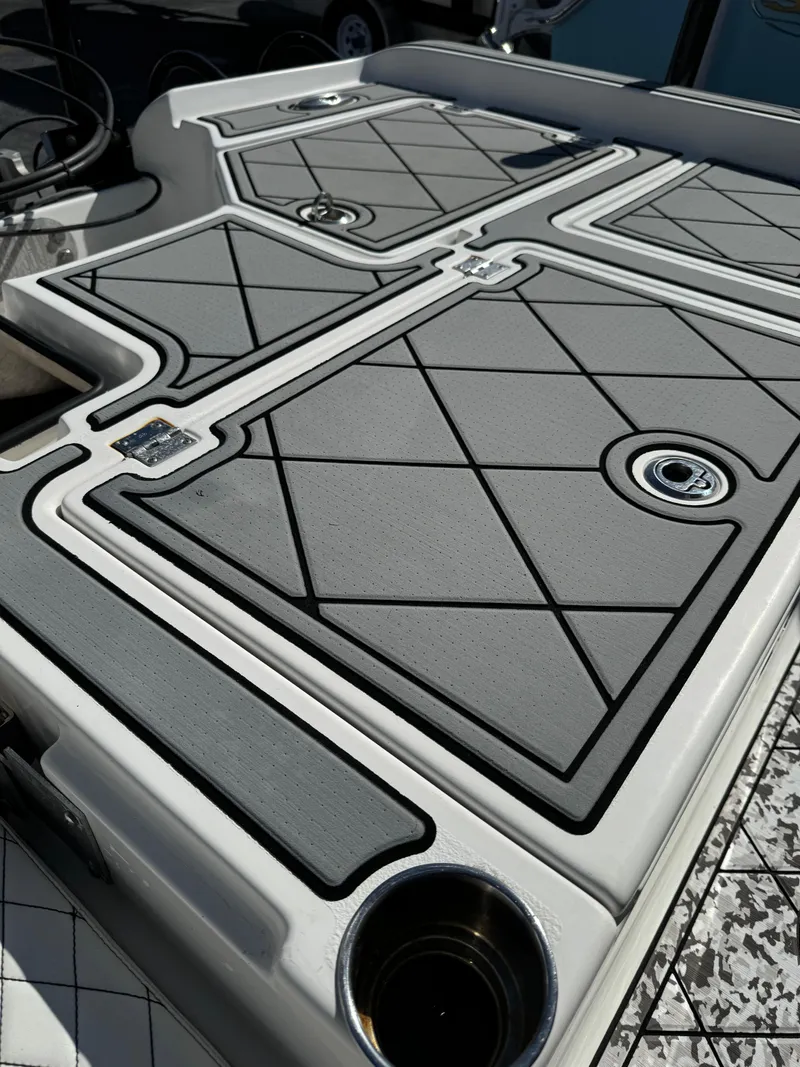 Slide: The Image of 2017 Action Craft 24 A.C.E. boat deck with textured gray panels and cup holders. - 44