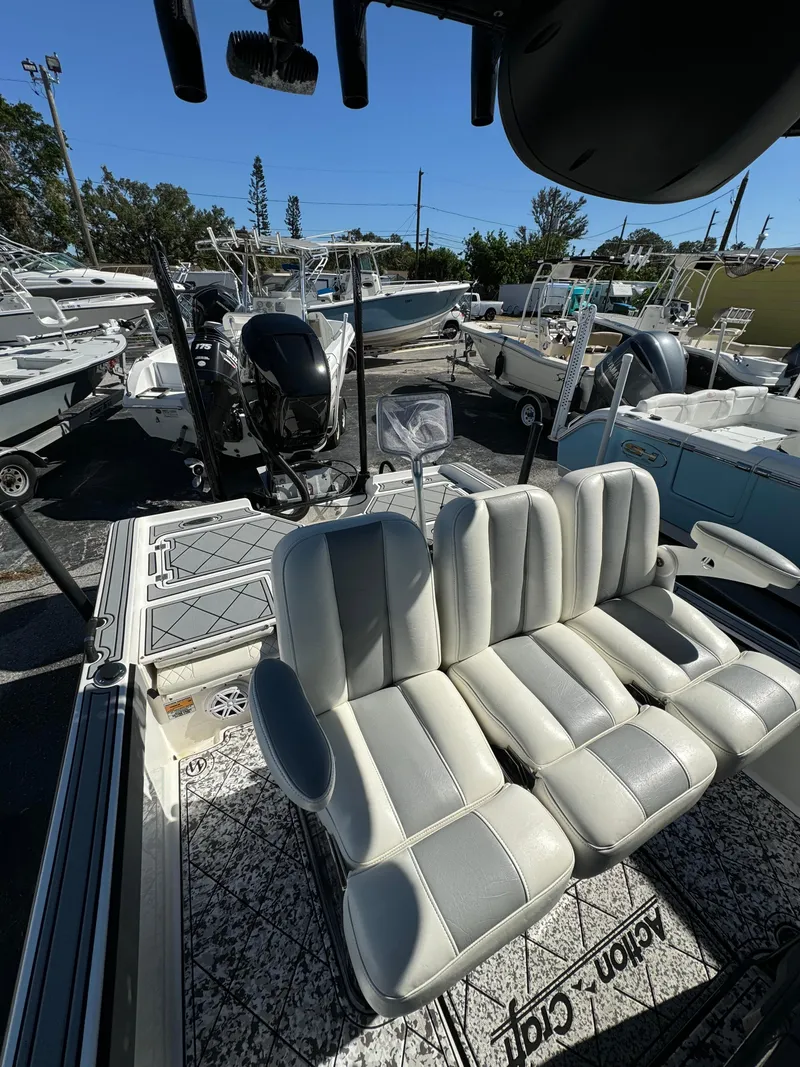 Slide: The Image of 2017 Action Craft 24 A.C.E. boat with cushioned seating, docked among other boats. - 6