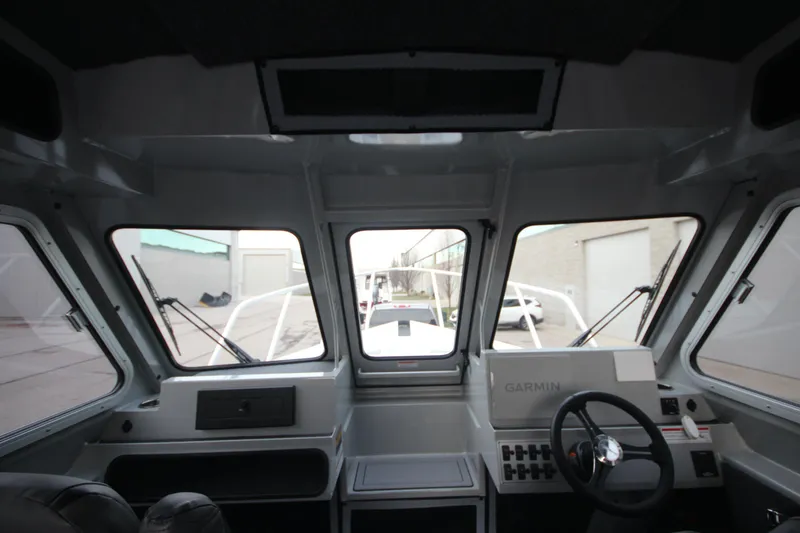Slide: The Image of Interior view of 2025 Weldcraft 240 Ocean King boat cockpit with steering wheel and controls. - 24