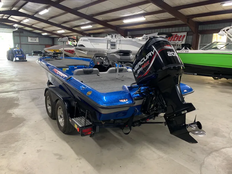 Slide: The Image of 1998 ProCraft 200 Bass boat with Mercury engine in a storage facility. - 4