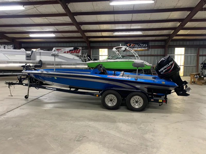 Slide: The Image of 1998 ProCraft 200 Bass boat in a showroom, blue with Mercury outboard motor. - 5