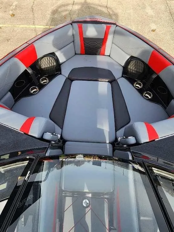 Slide: The Image of 2025 Malibu Wakesetter 23 LSV interior with gray and red seating, cup holders, and sleek design. - 10