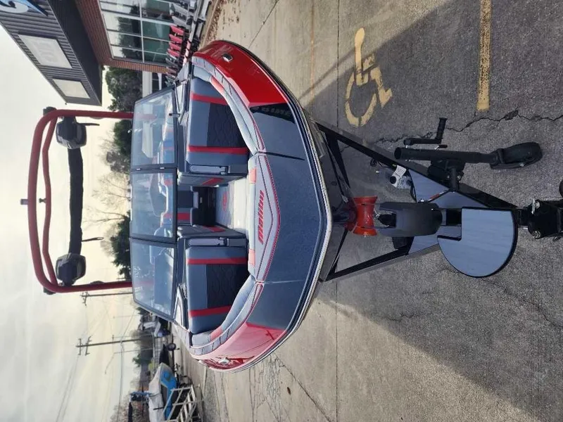 Slide: The Image of 2025 Malibu Wakesetter 23 LSV boat on trailer, red and gray design, parked outdoors. - 11