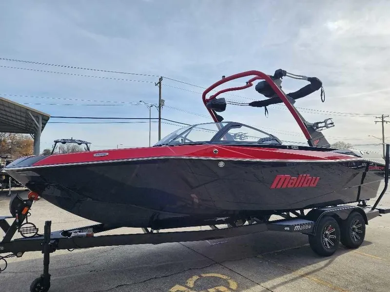 Slide: The Image of 2025 Malibu Wakesetter 23 LSV boat on trailer, red and black design, parked outdoors. - 9