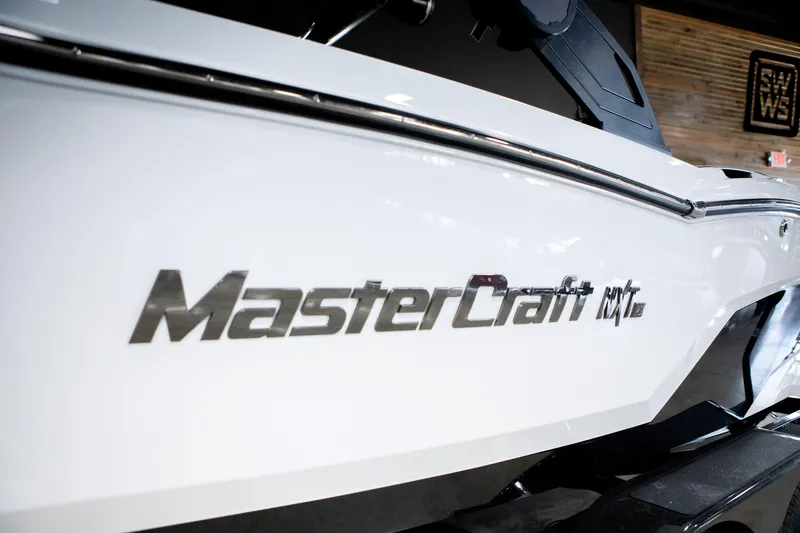 Slide: The Image of 2024 MasterCraft NXT20 boat, sleek white exterior with logo detail. - 1