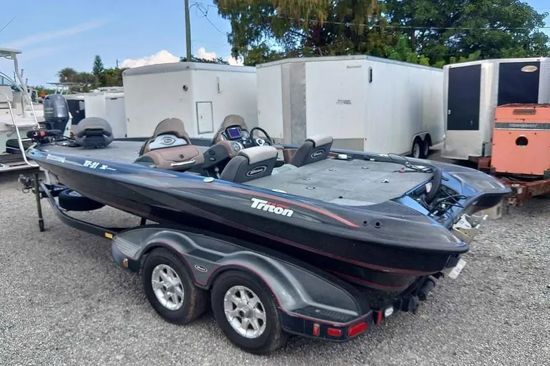 The Image of 2006 Triton TR-21X bass boat on trailer, parked outdoors. - 0
