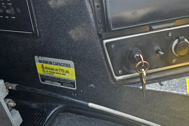 Slide: The Image of 2006 Triton Tr-21X HP boat storage compartments with open lids and wiring. - 17