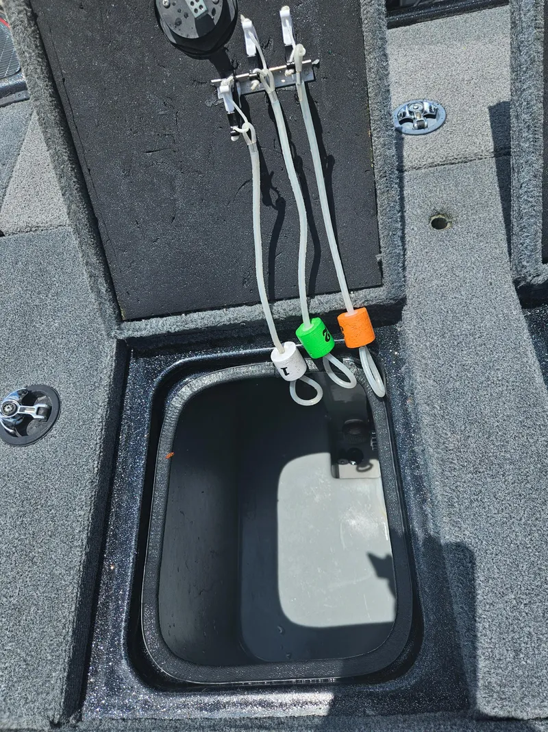 Slide: The Image of 2006 Triton Tr-21X HP boat storage compartment with open lid and latch. - 30