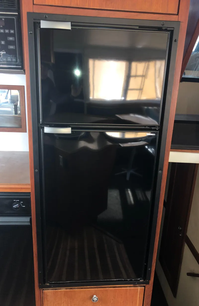 Slide: The Image of Black refrigerator inside 1996 Bayliner 4788 Pilot House Motoryacht kitchen area. - 11