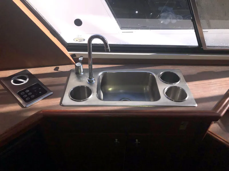 Slide: The Image of 1996 Bayliner 4788 Pilot House Motoryacht kitchen sink with faucet and cup holders. - 17