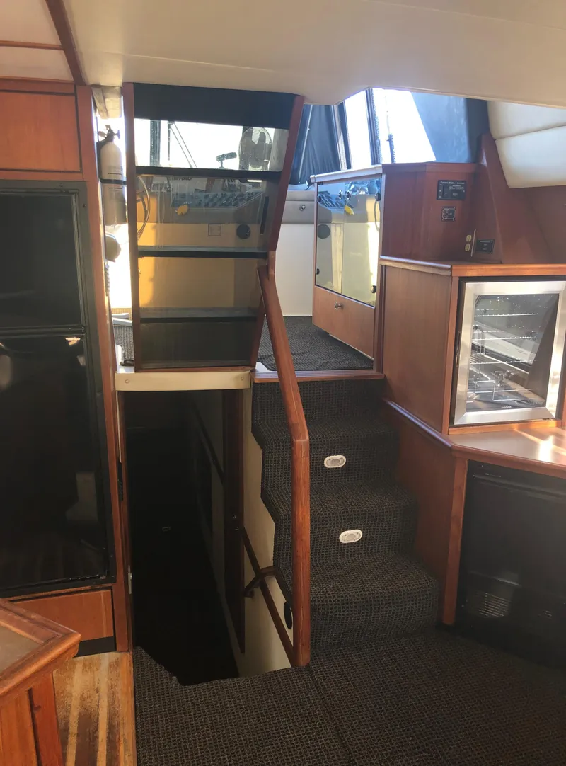 Slide: The Image of Interior of 1996 Bayliner 4788 Pilot House Motoryacht with stairs and wood paneling. - 18