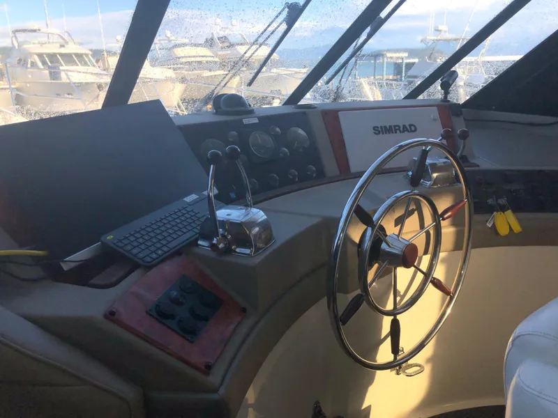 Slide: The Image of 1996 Bayliner 4788 Pilot House Motoryacht helm with steering wheel and navigation equipment. - 19