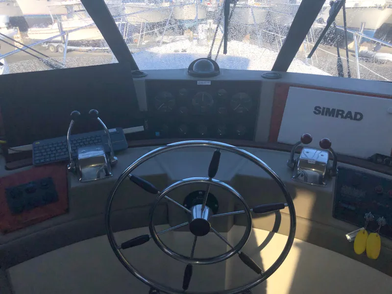 Slide: The Image of 1996 Bayliner 4788 Pilot House Motoryacht helm with steering wheel and navigation controls. - 20