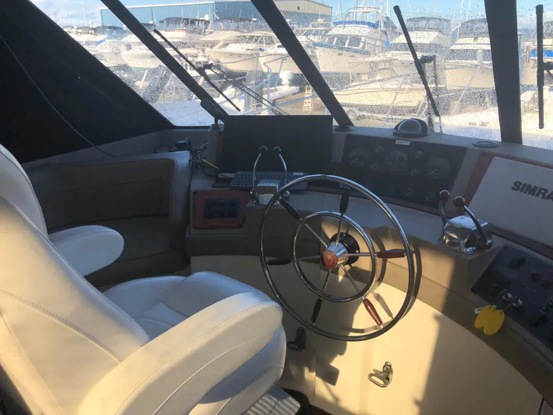 Slide: The Image of 1996 Bayliner 4788 Pilot House Motoryacht helm with steering wheel and navigation equipment. - 21