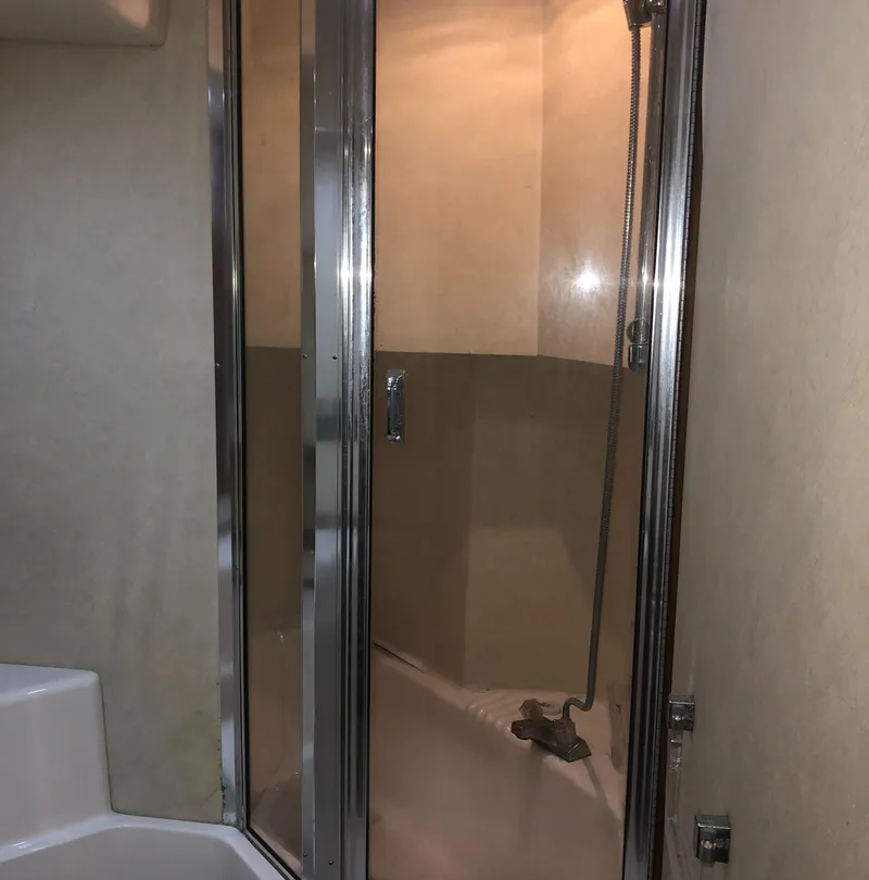 Slide: The Image of Shower area in 1996 Bayliner 4788 Pilot House Motoryacht with glass door and chrome fixtures. - 32