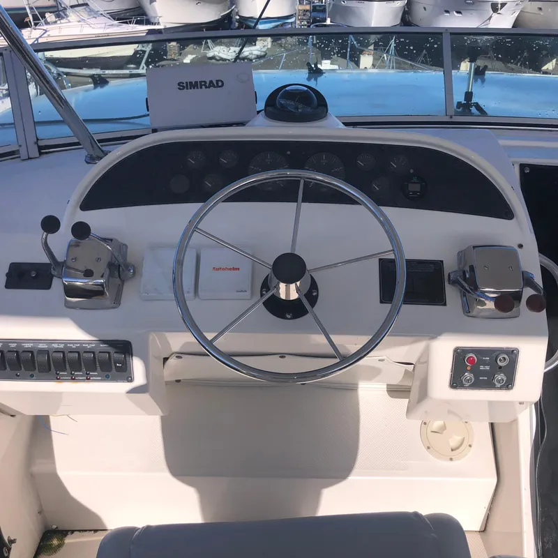 Slide: The Image of 1996 Bayliner 4788 Pilot House Motoryacht helm with steering wheel and controls. - 42