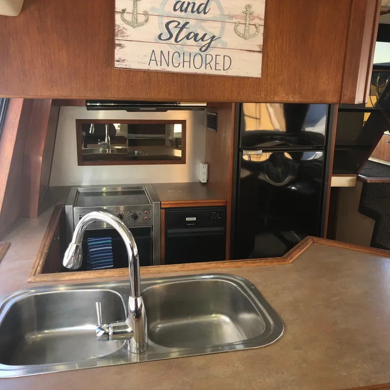 Slide: The Image of Interior of 1996 Bayliner 4788 yacht kitchen with sink, stove, and decor. - 7