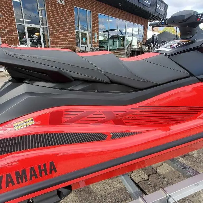 Slide: The Image of 2025 Yamaha WaveRunner VX Deluxe in vibrant red, parked outside a dealership. - 2