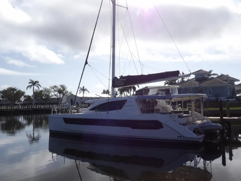Slide: The Image of 2014 Leopard 48 catamaran docked in a serene marina setting. - 1