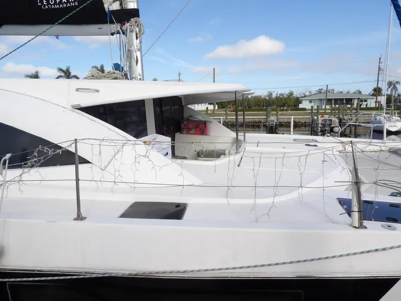 Slide: The Image of 2014 Leopard 48 catamaran docked, featuring sleek design and spacious deck. - 11