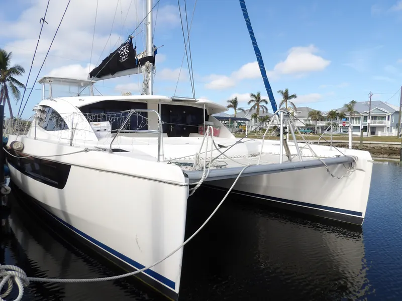 Slide: The Image of 2014 Leopard 48 catamaran docked in a marina with palm trees. - 13