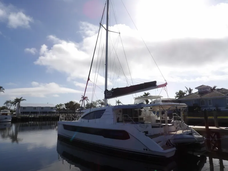 Slide: The Image of 2014 Leopard 48 catamaran docked in a sunny marina setting. - 2
