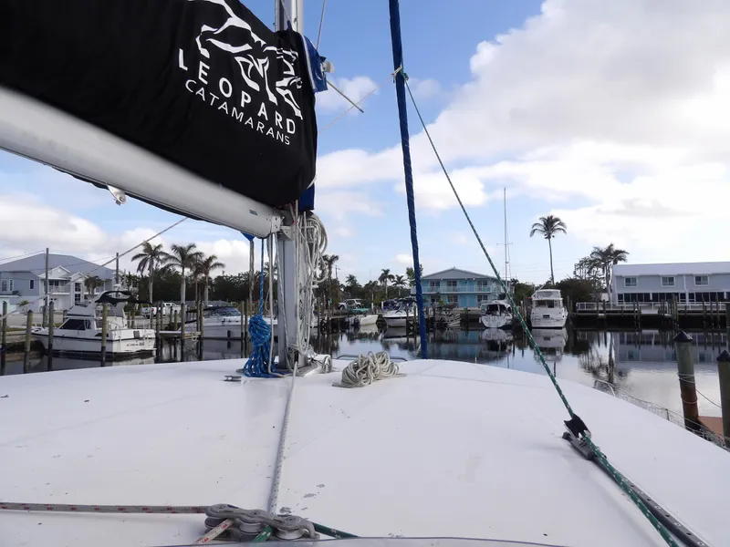 Slide: The Image of Leopard 48 catamaran docked at marina, 2014 model, with palm trees and boats in background. - 30