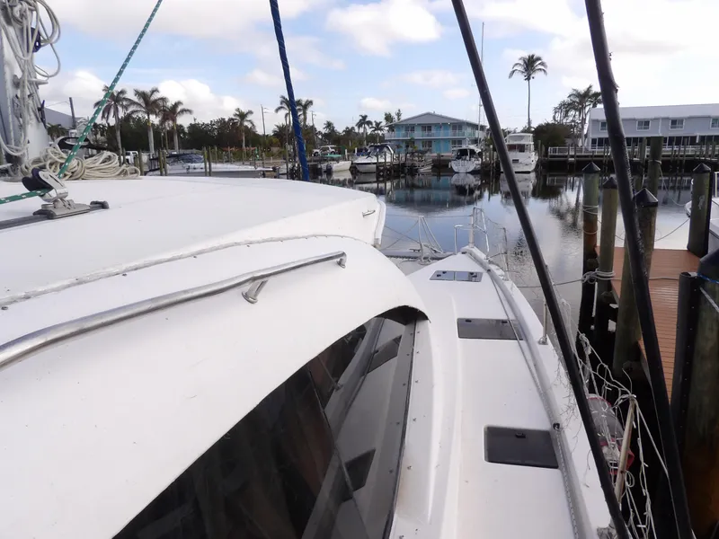 Slide: The Image of Leopard 48 catamaran docked in marina, 2014 model, with palm trees and waterfront homes. - 34