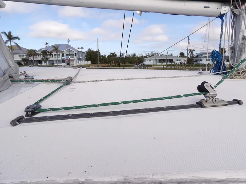 Slide: The Image of Leopard 48 sailboat deck with rigging, 2014 model, coastal homes in background. - 35