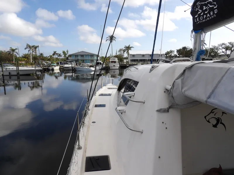 Slide: The Image of Leopard 48 yacht docked in a marina, reflecting calm waters and palm trees. - 39