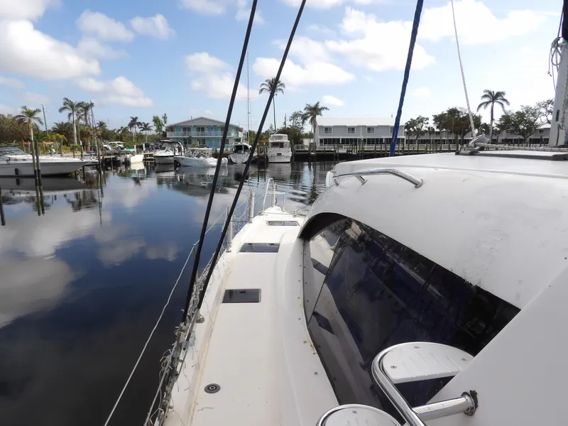 Slide: The Image of Leopard 48 yacht docked in a serene marina, surrounded by palm trees and calm waters. - 41