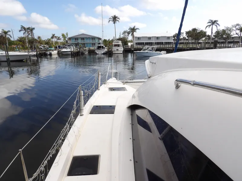 Slide: The Image of Leopard 48 yacht docked in a marina, 2014 model, with calm water and palm trees. - 43