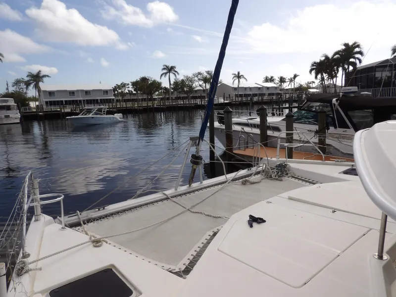 Slide: The Image of 2014 Leopard 48 catamaran docked in a marina with palm trees and boats. - 45