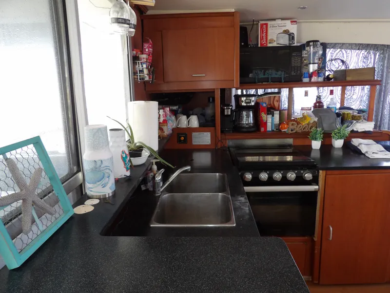 Slide: The Image of Modern kitchen in 2014 Leopard 48 yacht with sink, stove, and wooden cabinets. - 49