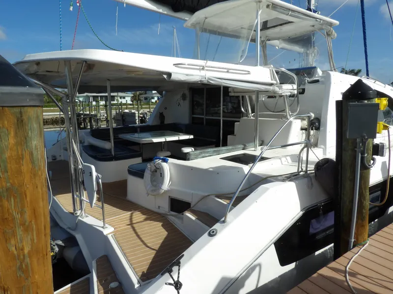 Slide: The Image of 2014 Leopard 48 yacht docked, featuring spacious deck and seating area. - 6