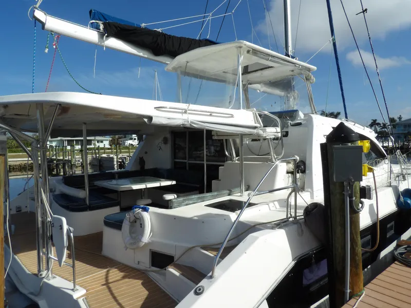 Slide: The Image of 2014 Leopard 48 catamaran docked, featuring spacious deck and seating area. - 7