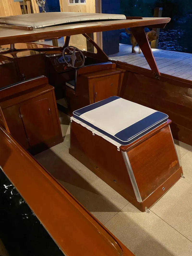 Slide: The Image of 1962 Lyman 24 Sleeper Hardtop boat interior with wooden finish and cushioned seating. - 16