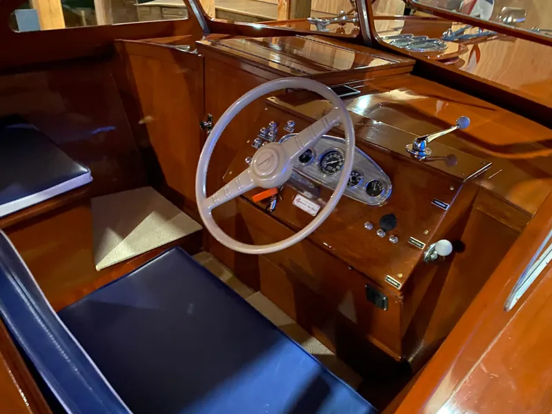 Slide: The Image of 1962 Lyman 24 Sleeper Hardtop boat interior with wooden dashboard and blue seating. - 19