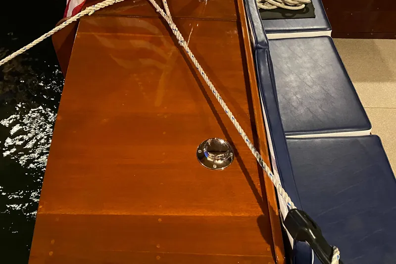 Slide: The Image of 1962 Lyman 24 Sleeper Hardtop boat with wooden deck and blue seating. - 21