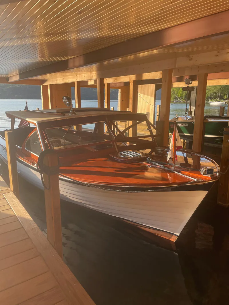 Slide: The Image of 1962 Lyman 24 Sleeper Hardtop boat docked in a wooden boathouse. - 22