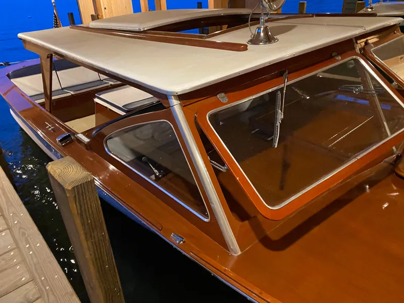Slide: The Image of 1962 Lyman 24 Sleeper Hardtop boat with wooden finish, docked in a marina. - 23