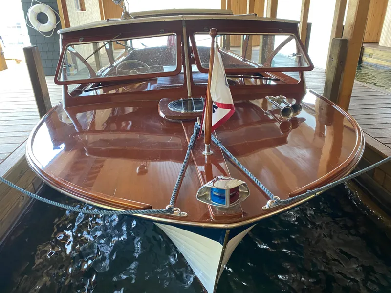 Slide: The Image of 1962 Lyman 24 Sleeper Hardtop boat docked in a wooden boathouse. - 24