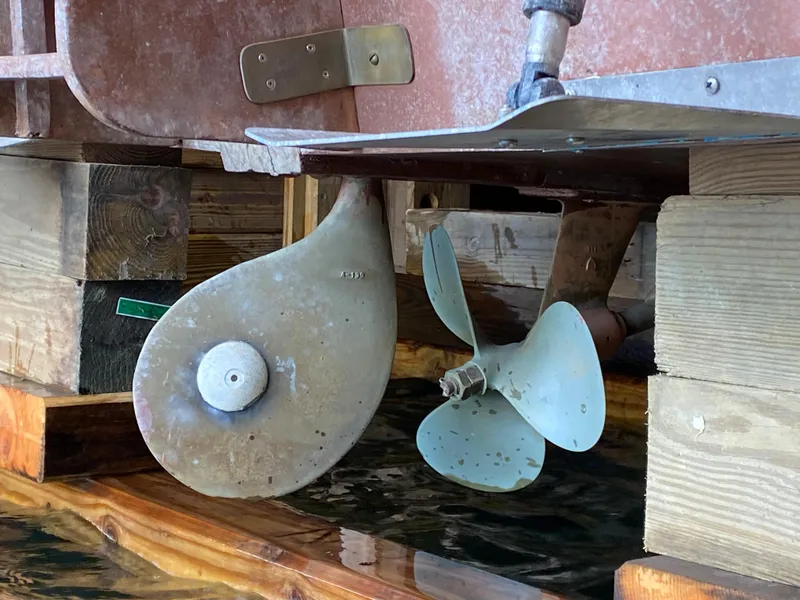 Slide: The Image of 1962 Lyman 24 Sleeper Hardtop boat propeller and rudder in dry dock. - 25